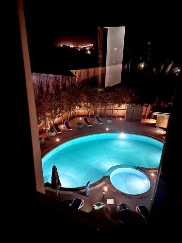 a swimming pool at night with chairs and lights at Giza Palace Pyramids View in Cairo