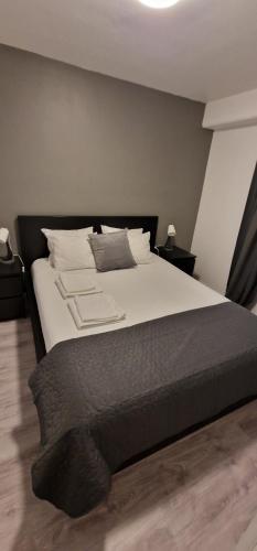 a bedroom with a large bed with white sheets and pillows at Modern and Central Apartment, 6 mins to Oslo City in Oslo