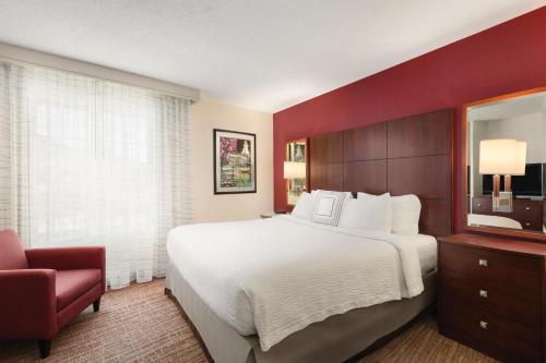 a hotel room with a large bed and a chair at Residence Inn by Marriott Newport Middletown in Middletown