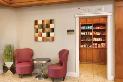 a waiting room with two chairs and a table and a shelf at Residence Inn by Marriott Newport Middletown in Middletown