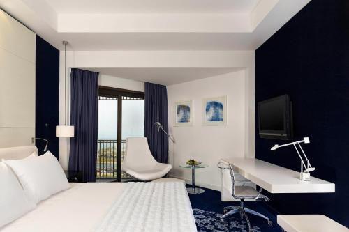 a hotel room with a bed and a desk with a computer at Le Meridien Al Khobar in Al Khobar