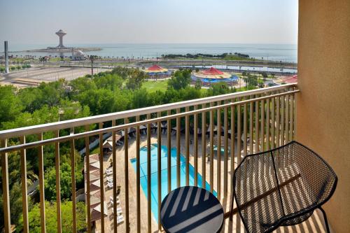 a balcony with a chair and a view of the ocean at Le Meridien Al Khobar in Al Khobar