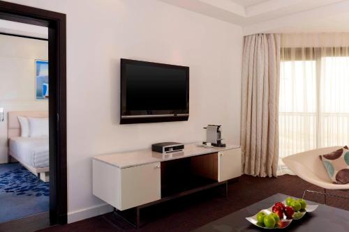 a hotel room with a television on a wall at Le Meridien Al Khobar in Al Khobar