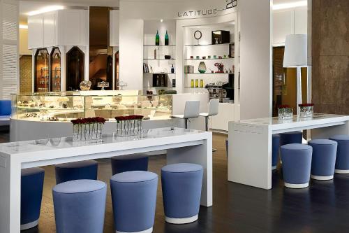 a store with a counter with blue stools at Le Meridien Al Khobar in Al Khobar