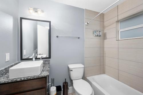 a bathroom with a sink and a toilet and a mirror at Chic 1BR Stay with King Bed and Free Park in Houston