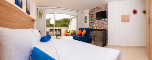 a bedroom with a white bed and a blue chair at Suite de lujo en San Gil in San Gil
