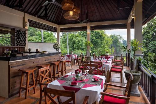 a dining room with tables and chairs in a restaurant at Griya Shanti Villas & Spa in Ubud