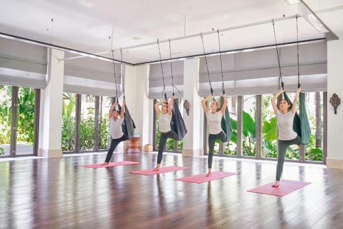 a group of people doing yoga in a room at The Ritz-Carlton Bali in Nusa Dua