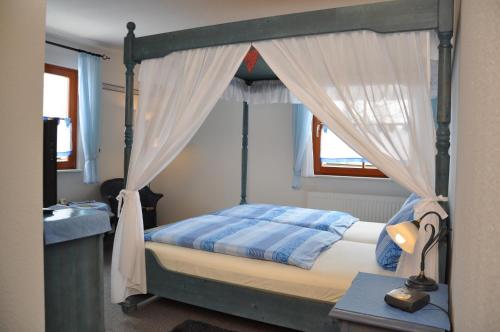 ein Schlafzimmer mit einem Himmelbett mit Baldachin in der Unterkunft Steakhouse & Pension Crazy Horse in Suhl