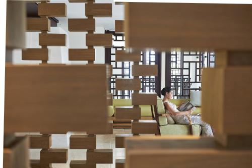 a woman sitting in a chair with a laptop at The Ritz-Carlton Bali in Nusa Dua