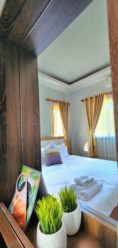a bedroom with a large bed with two potted plants at Sisters Real Escapes -Private Room With Private Bathroom in Mae Sot