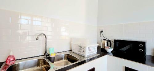 a kitchen with a sink and a microwave at Sisters Real Escapes -Private Room With Private Bathroom in Mae Sot