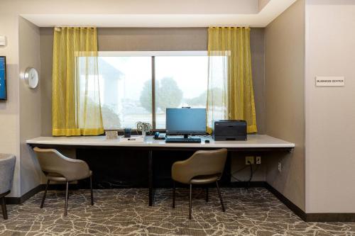 an office with a desk with a computer and chairs at SpringHill Suites Florence in Florence