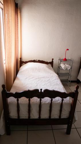 a bed in a bedroom with a red lamp on a table at Casa Calas in Alajuela City