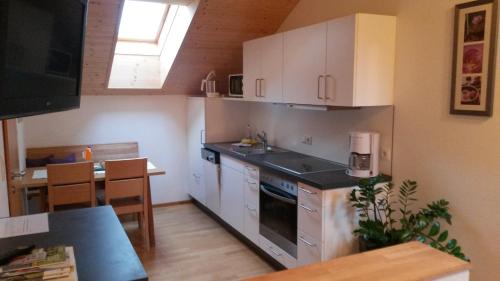 a kitchen with white cabinets and a table in it at Haus Hagspiel in Hittisau