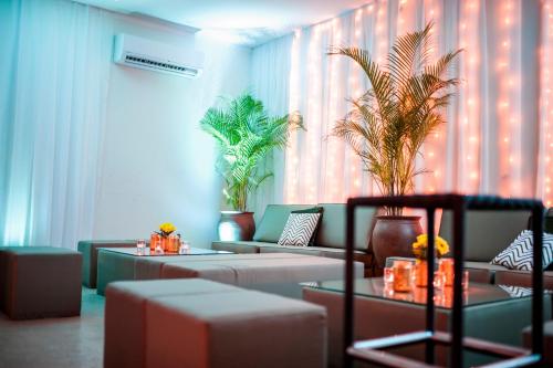 uma sala de estar com sofás e plantas em Tropical Enclave Hotel em Accra