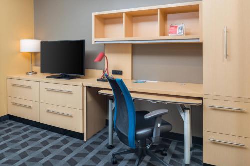 an office with a desk with a computer monitor and a chair at TownePlace Suites by Marriott New Hartford in New Hartford