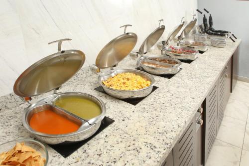 a row of bowls of food on a counter in a kitchen at voco Saltillo Suites by IHG in Saltillo