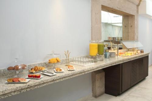 a buffet line with plates of food on it at voco Saltillo Suites by IHG in Saltillo