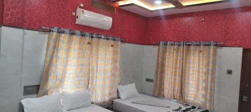 a room with curtains and a bed and a couch at SAMRAT HOME STAY in Hampi