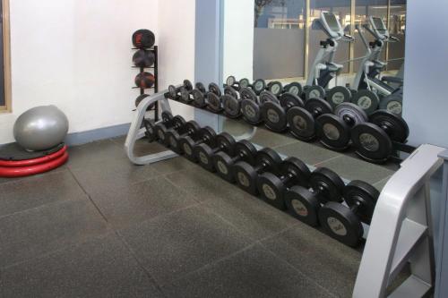 a gym with a row of dumbbells on a wall at voco Saltillo Suites by IHG in Saltillo