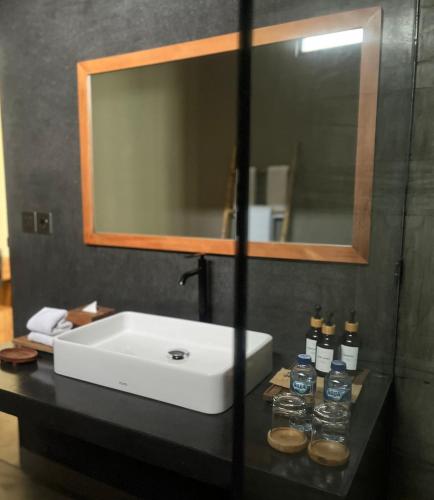 a bathroom with a white sink and a mirror at Tropical Almond Villa in Uluwatu