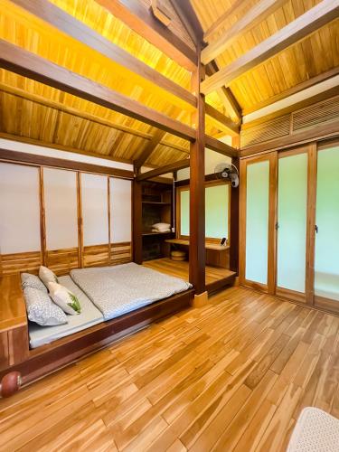 a bedroom with a bed and wooden floors at HARMONY Botanic in Buon Ma Thuot