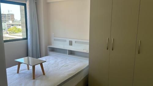 a small bedroom with a bed and a table at Flat Manaira in João Pessoa