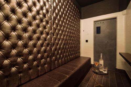 a leather wall with a couch in a room at Courthouse Hotel Shoreditch in London