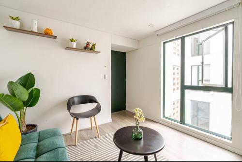 a living room with a green couch and a chair at Cómodo y silencioso Apartamento 1BR en Barranco in Lima
