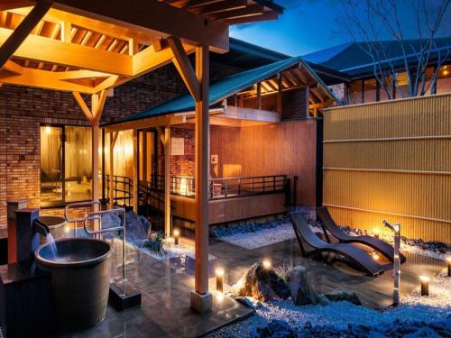 a patio with a fire pit and a building at Sennomori in Ise