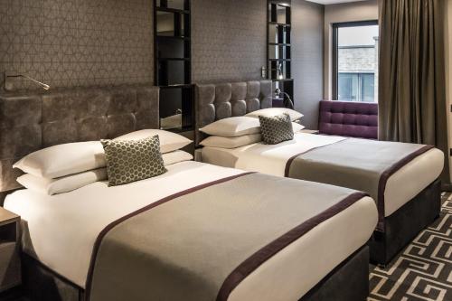 a hotel room with two beds in a room at Courthouse Hotel Shoreditch in London