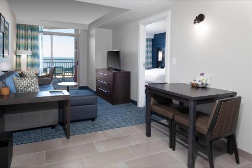 a living room with a desk and a dining room at Residence Inn By Marriott Virginia Beach Oceanfront in Virginia Beach