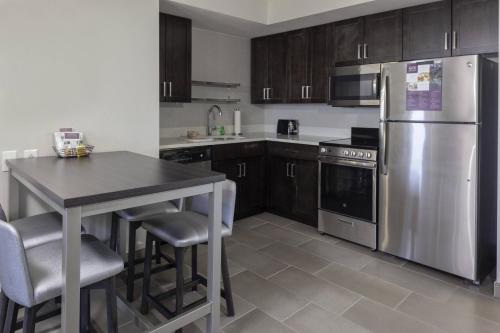 a kitchen with a stainless steel refrigerator and a table at Residence Inn By Marriott Virginia Beach Oceanfront in Virginia Beach