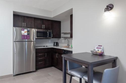 a kitchen with a stainless steel refrigerator and a table at Residence Inn By Marriott Virginia Beach Oceanfront in Virginia Beach