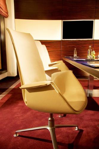 two white chairs sitting next to a table at The Westin Grand Berlin in Berlin
