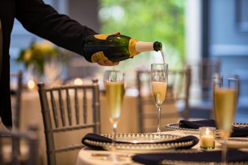 a person pouring champagne into glasses on a table at Portland Sheraton at Sable Oaks in South Portland
