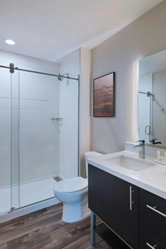 a bathroom with a toilet and a glass shower at TownePlace Suites by Marriott Dallas DFW Airport North/Irving in Irving