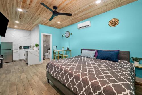 ヒューストンにあるModern Studio Retreat with King Bed, Full Kitchen & Free Parkのベッドと天井扇風機のある寝室