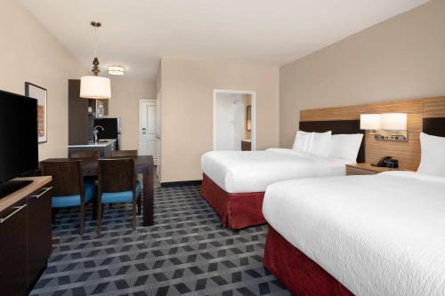 a hotel room with two beds and a desk at TownePlace Suites by Marriott Twin Falls in Twin Falls