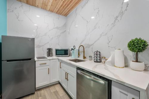a kitchen with white cabinets and a stainless steel refrigerator at Modern Studio Retreat with King Bed, Full Kitchen & Free Park in Houston