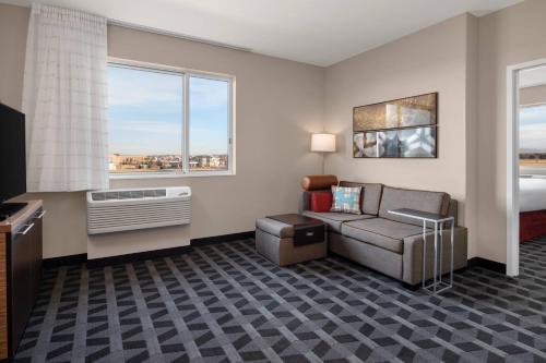 a hotel room with a couch and a bed and window at TownePlace Suites by Marriott Twin Falls in Twin Falls