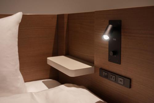 a bedroom with a bed and a sink on a wall at the b osaka-shinsekai in Osaka