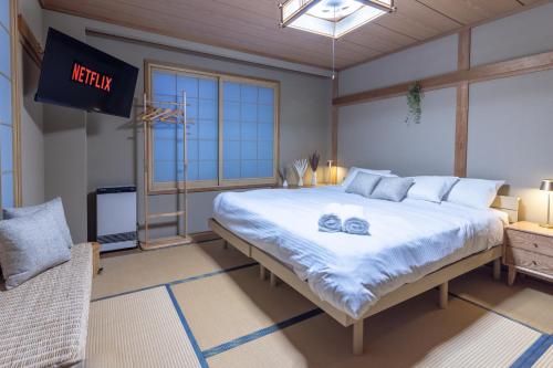 a bedroom with a large bed with two towels on it at Welcome Nozawa in Nozawa Onsen