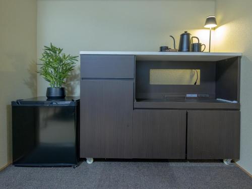 a kitchen with a microwave and a potted plant at Welcome Nozawa in Nozawa Onsen