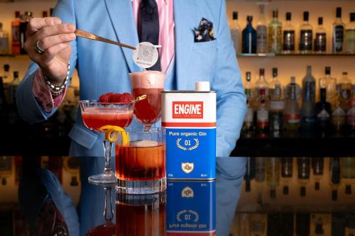 a man in a suit standing behind a bar making a drink at London Marriott Hotel Canary Wharf in London