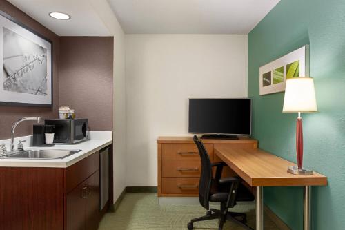 a room with a desk with a computer and a television at SpringHill Suites Boca Raton in Boca Raton