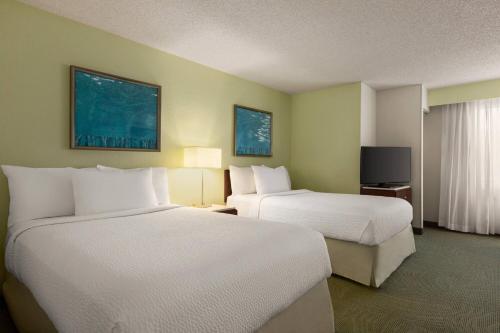 a hotel room with two beds and a television at SpringHill Suites Boca Raton in Boca Raton