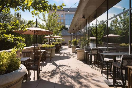 an outdoor patio with tables and chairs and umbrellas at The Westin Reston Heights in Reston