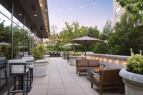 a patio with tables and chairs and an umbrella at The Westin Reston Heights in Reston